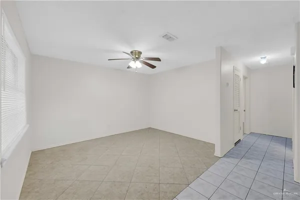 an empty room with chandelier fan