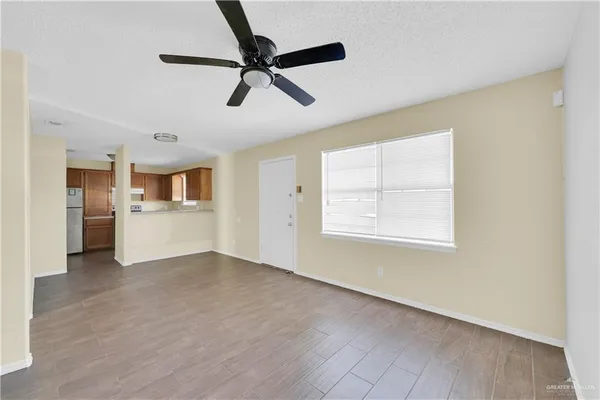 a view of a livingroom with a ceiling fan & windows