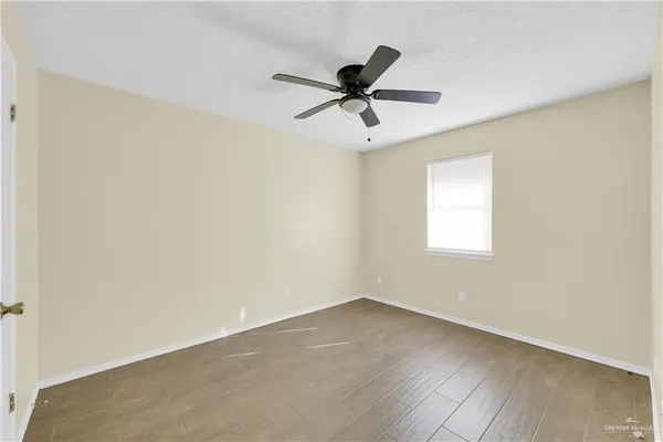 a view of a big room with wooden floor and windows