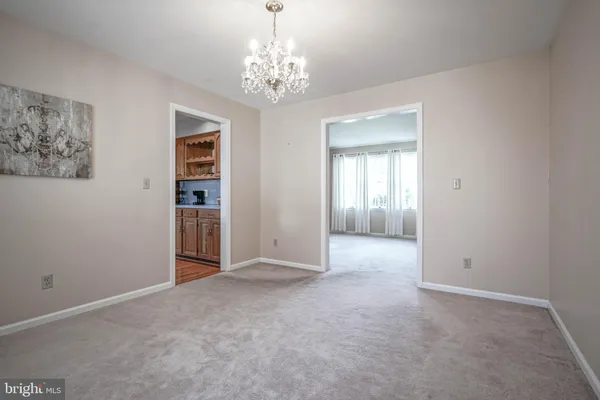 a kitchen with stainless steel appliances granite countertop a refrigerator a sink dishwasher a dining table and chairs with wooden floor