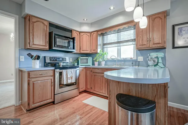 a kitchen with stainless steel appliances granite countertop a sink stove and cabinets