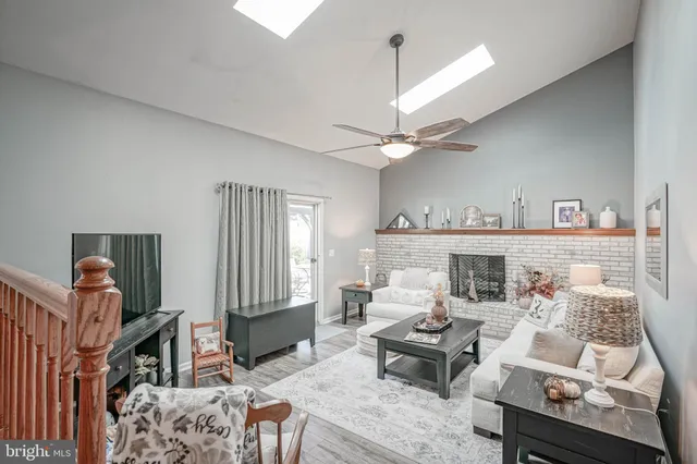 a living room with furniture a fireplace and a chandelier