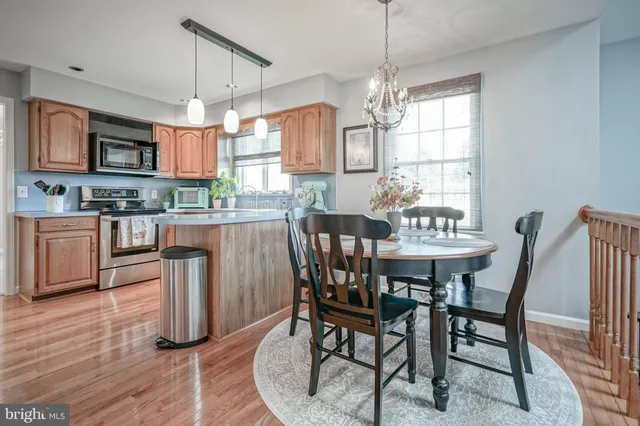 a dining room with furniture a chandelier and wooden floor