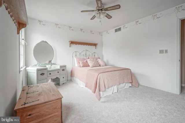 an empty room with windows and chandelier fan