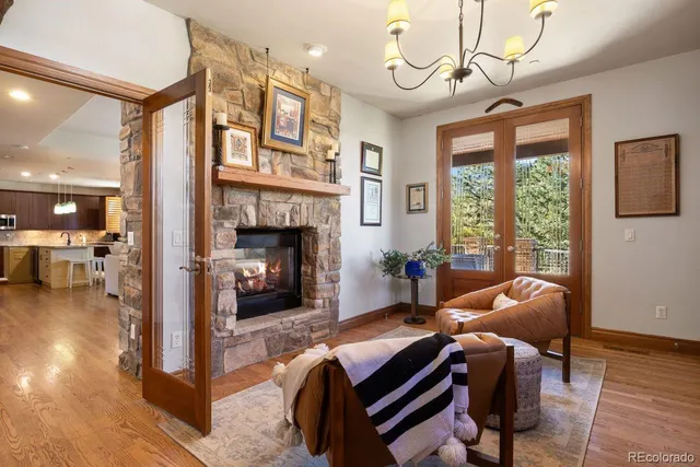 a living room with furniture a fireplace and a chandelier
