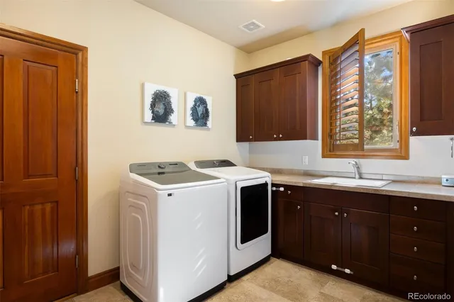 a utility room with sink dryer and washer