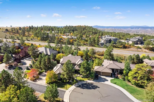 a view of a white house with a big yard and large trees