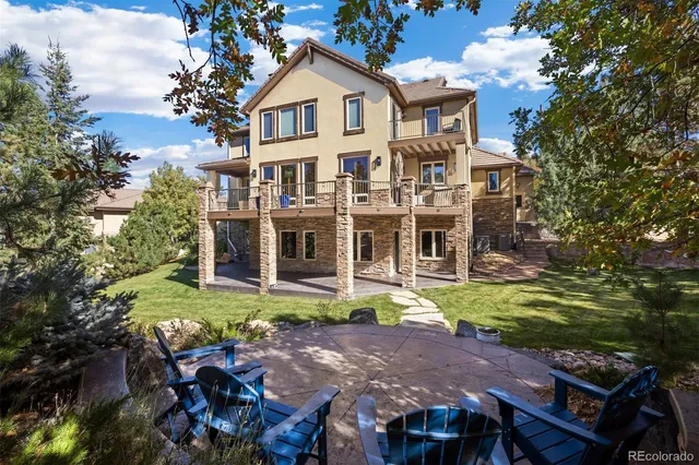 a view of a white house with a big yard and large trees