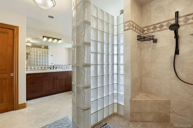 a bathroom with a double vanity sink a toilet and shower