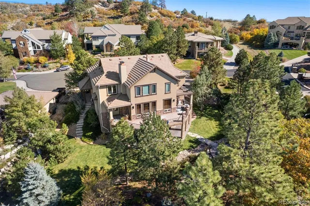 an aerial view of residential houses with outdoor space and trees