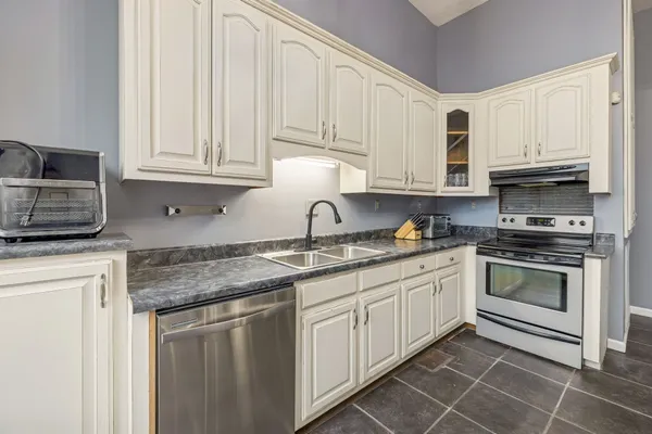 a kitchen with stainless steel appliances granite countertop a sink stove and microwave