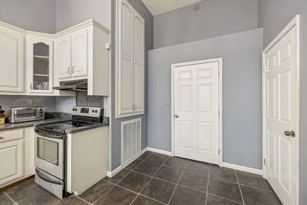 a kitchen with white cabinets and white appliances
