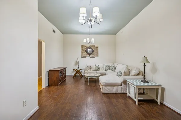 a living room with furniture chandelier and a window