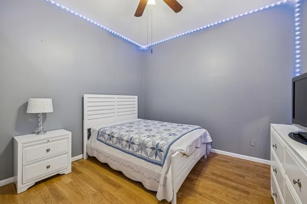 a bedroom with a bed and a lamp on the dresser