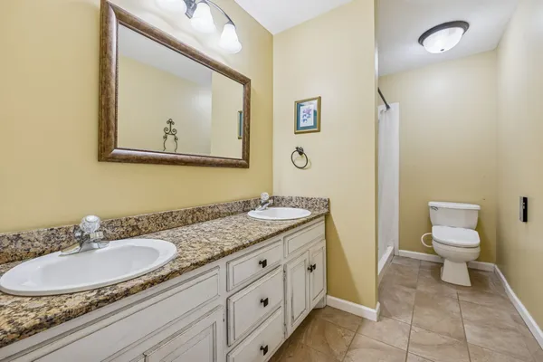a bathroom with a granite countertop sink mirror and toilet