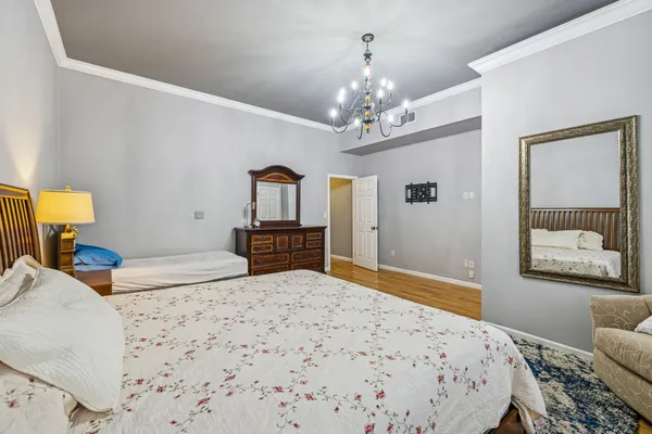 a bedroom with a bed chandelier and a window