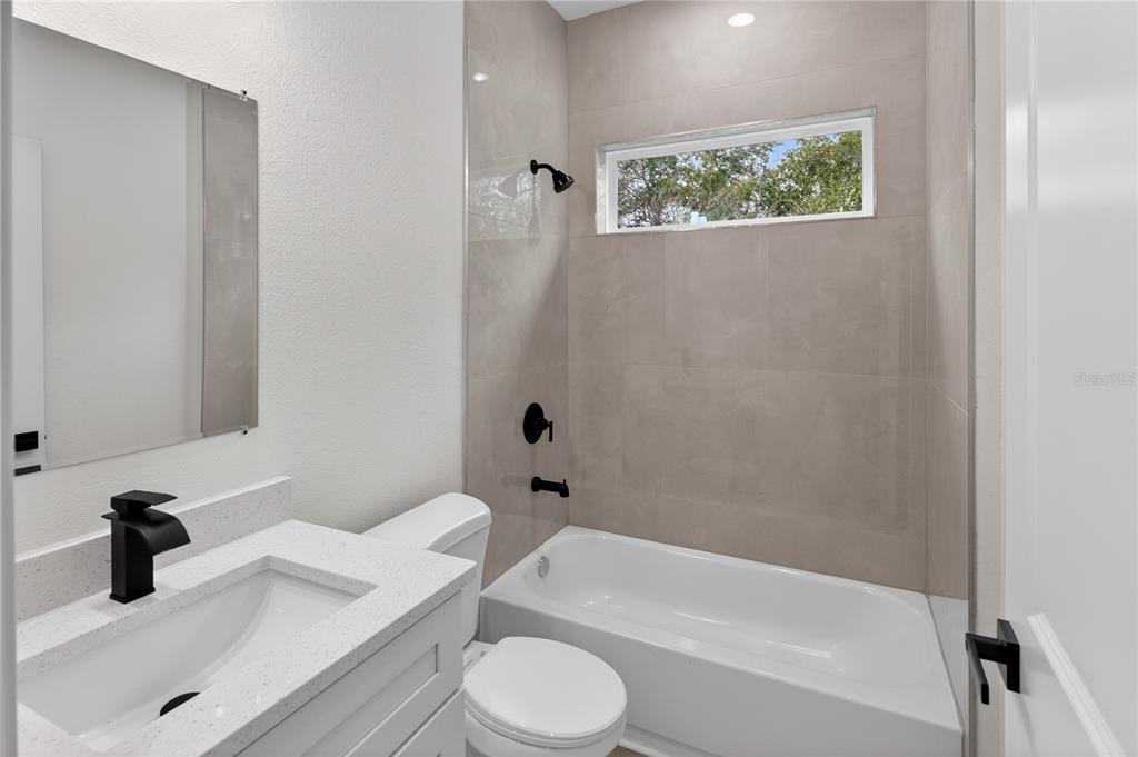 15028 Southwest 25th Circle Ocala, FL 34473 - Photo 12 of 35 a bathroom with a granite countertop bathtub sink vanity mirror and toilet