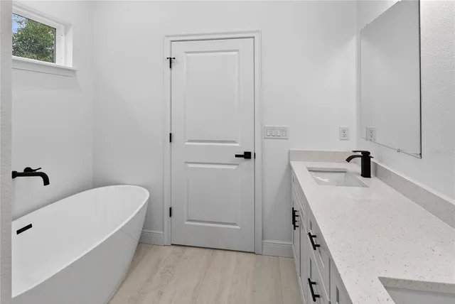 a bathroom with a tub sink and vanity