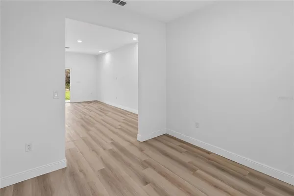 a view of an empty room with wooden floor