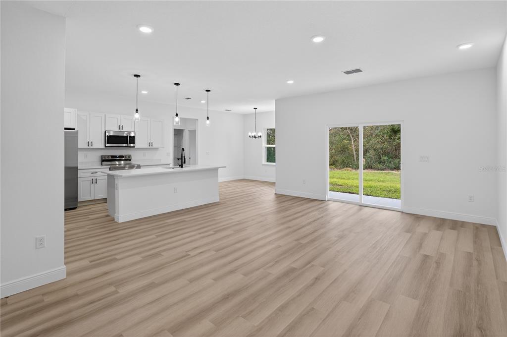 15028 Southwest 25th Circle Ocala, FL 34473 - Photo 4 of 35 an empty room with wooden floor and windows