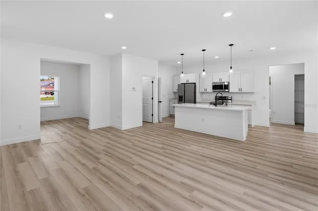 a view of kitchen view wooden floor stainless steel appliances and cabinets