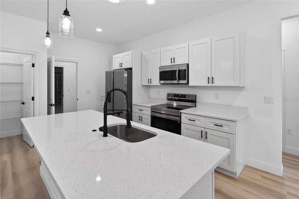 15028 Southwest 25th Circle Ocala, FL 34473 - Photo 7 of 35 a kitchen with stainless steel appliances a stove microwave and refrigerator