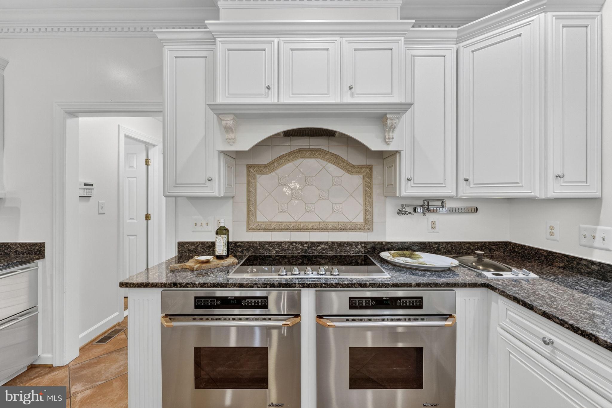 4531 Den Haag Road Warrenton, VA 20187 - Photo 22 of 103 a kitchen with granite countertop white cabinets and stainless steel appliances