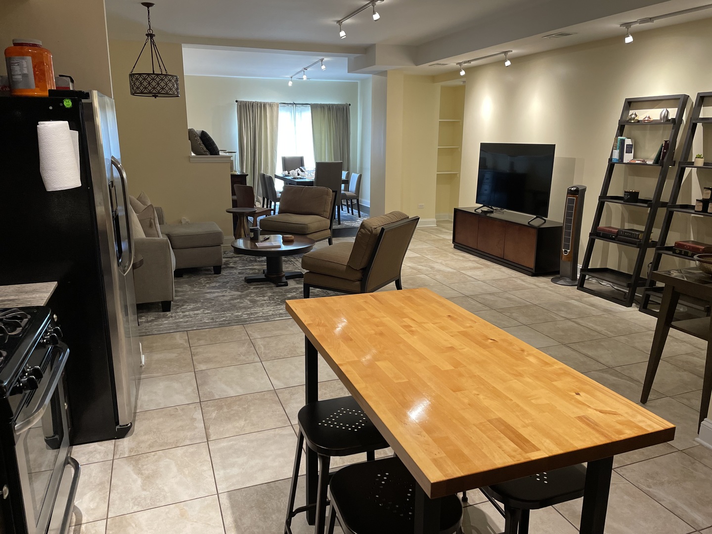 2801 West Ardmore Avenue, Unit 1A Chicago, IL 60659 - Photo 9 of 12 a living room with furniture a flat screen tv and a refrigerator