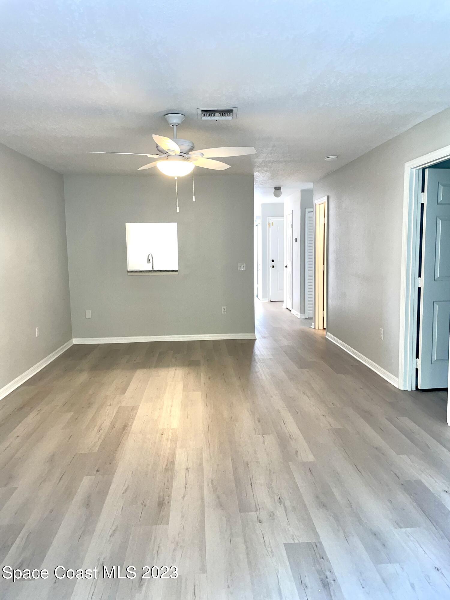179 Shell Place, Unit 36 Rockledge, FL 32955 - Photo 7 of 20 wooden floor in an empty room with a window