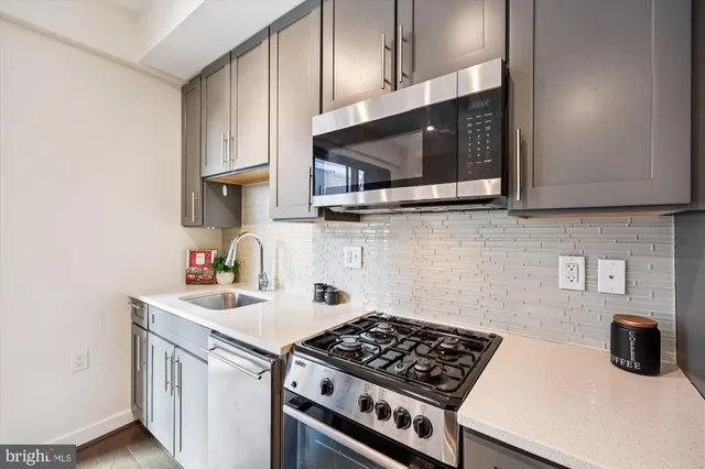 a kitchen with stainless steel appliances a sink a stove and cabinets