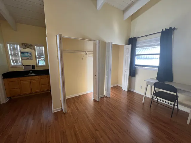 a view of a room with wooden floor lounge chair and windows