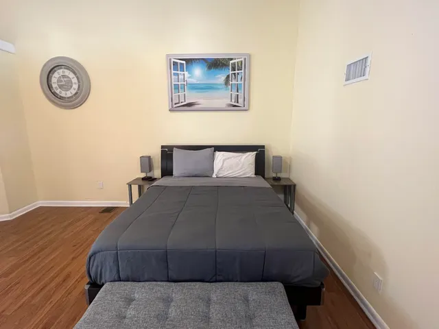 a bedroom with a bed and a table with wooden floor