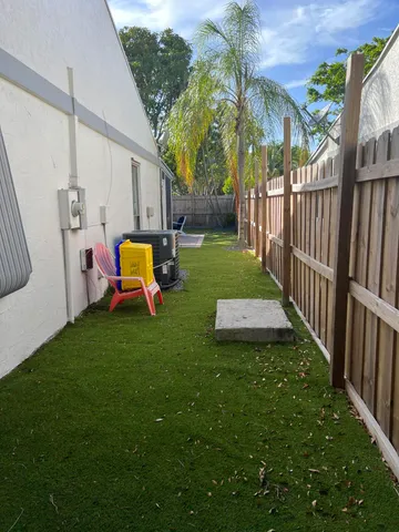a view of a backyard with table and chairs and wooden fence