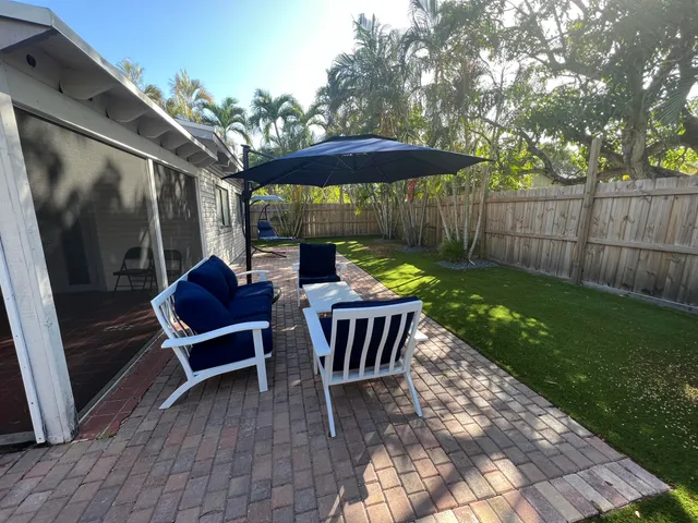 a view of backyard with outdoor seating and trees