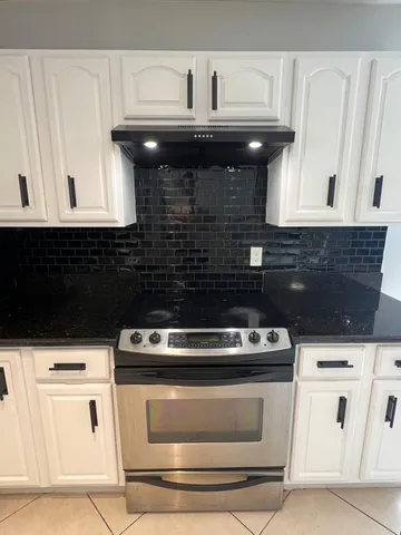 a stove top oven sitting inside of a kitchen