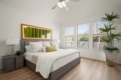 a bedroom with a large bed and a potted plant