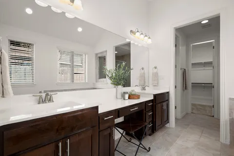 a bathroom with a sink double vanity granite tub shower and a mirror