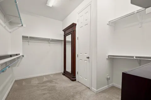 a view of walk in closet with empty racks