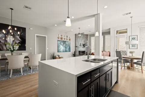 a large kitchen with kitchen island a dining table chairs and a wooden floor