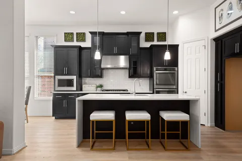 a kitchen with stainless steel appliances a sink and cabinets