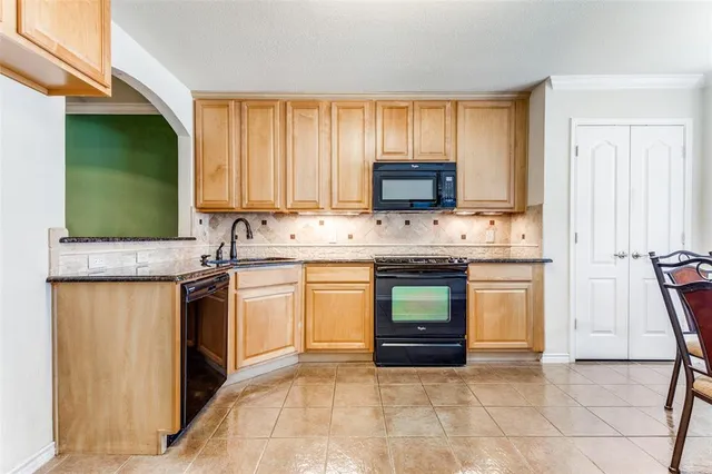 a kitchen with stainless steel appliances granite countertop a stove a sink and a microwave