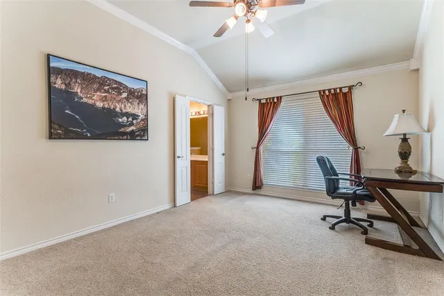 a view of a workspace with furniture and a window