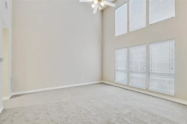an empty room with chandelier fan