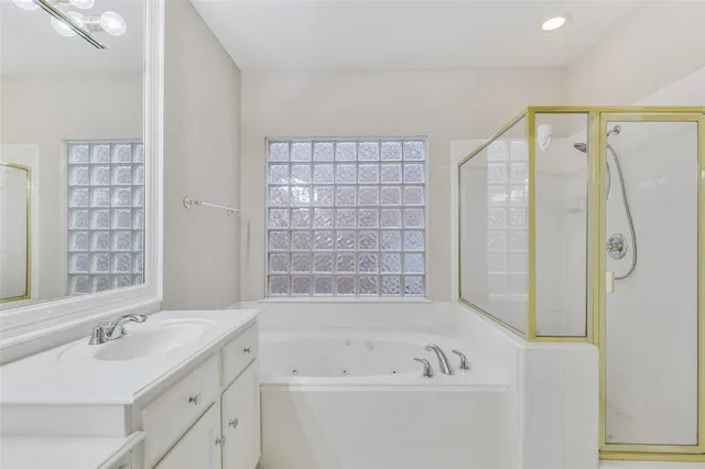 a bathroom with a tub sink and mirror