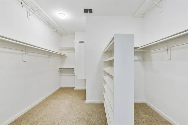 a view of walk in closet with empty racks