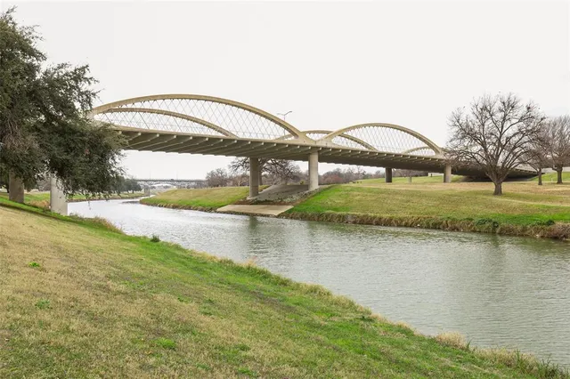 a view of a lake with a big yard and large trees
