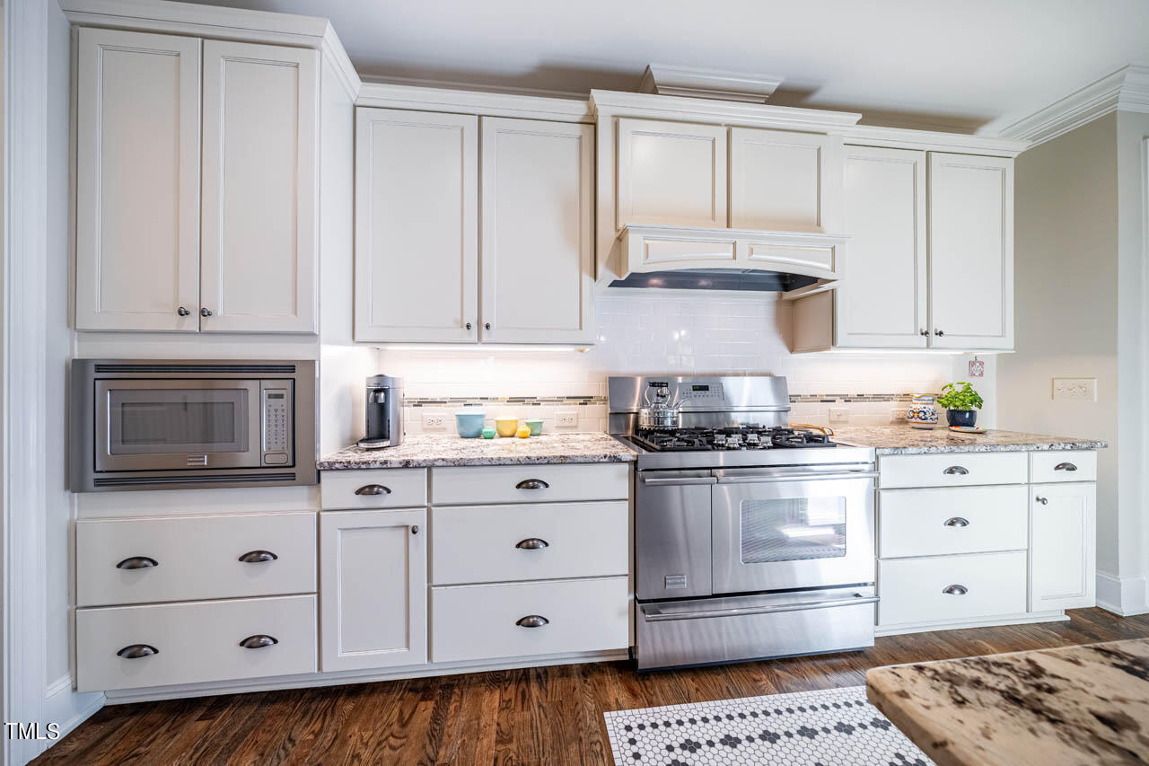 499 Bennett Mountain Trace Chapel Hill, NC 27516 - Photo 21 of 75 a kitchen with granite countertop white cabinets and stainless steel appliances