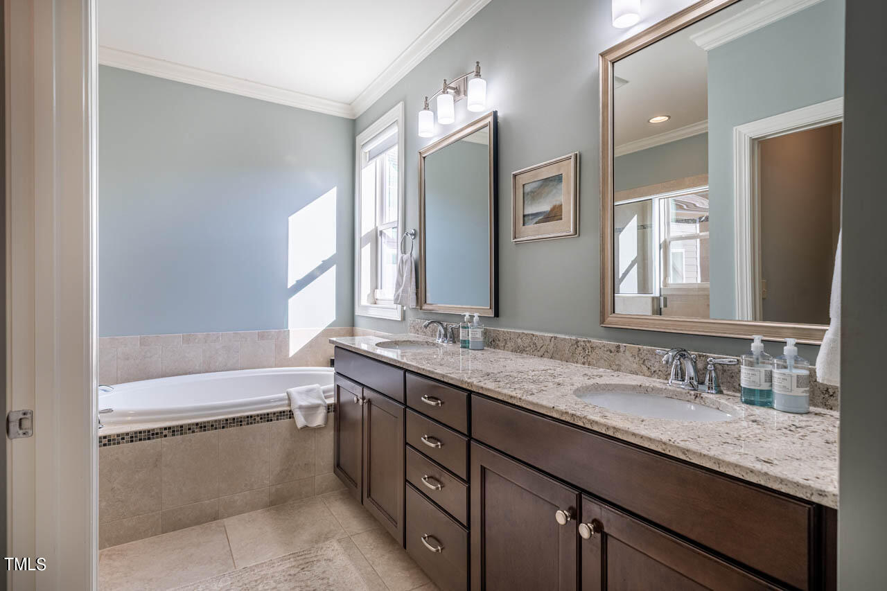 499 Bennett Mountain Trace Chapel Hill, NC 27516 - Photo 42 of 75 a bathroom with a granite countertop sink mirror and a bathtub