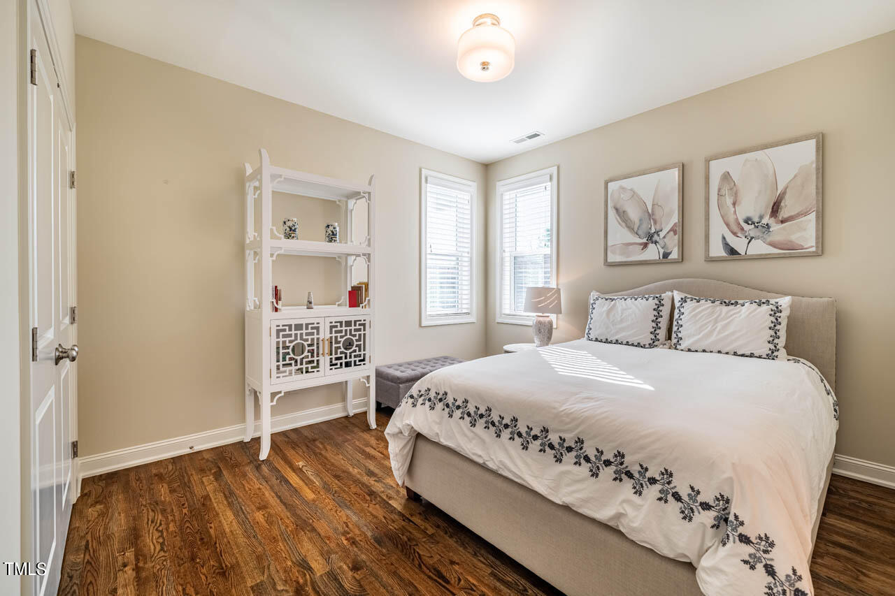 499 Bennett Mountain Trace Chapel Hill, NC 27516 - Photo 53 of 75 a bedroom with a large bed and a chandelier