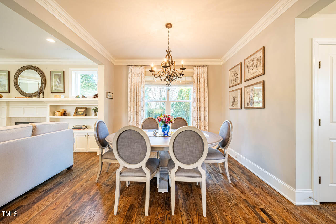 499 Bennett Mountain Trace Chapel Hill, NC 27516 - Photo 10 of 75 a dining room with furniture a chandelier and wooden floor